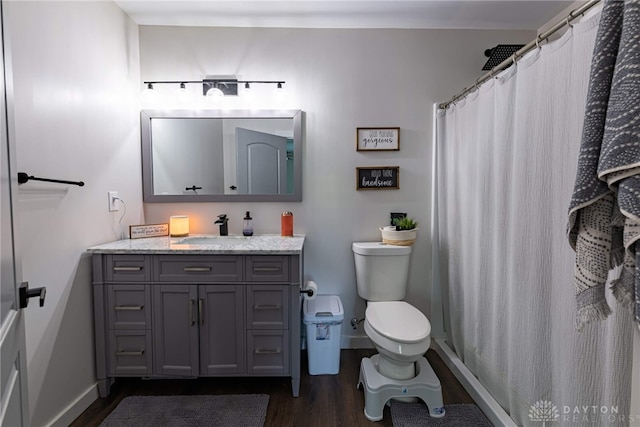 bathroom with hardwood / wood-style floors, vanity, toilet, and a shower with curtain