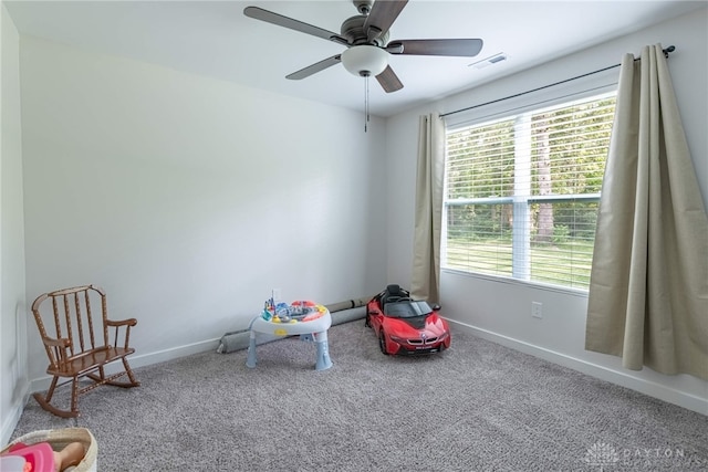 recreation room featuring carpet, ceiling fan, and a healthy amount of sunlight