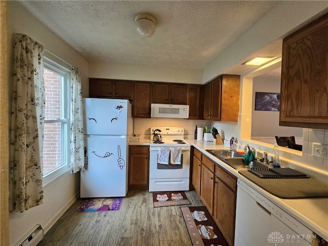 kitchen with decorative backsplash, white appliances, a textured ceiling, wood-type flooring, and a baseboard radiator