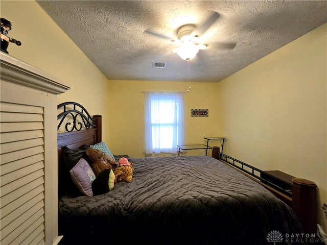 bedroom with a textured ceiling and ceiling fan