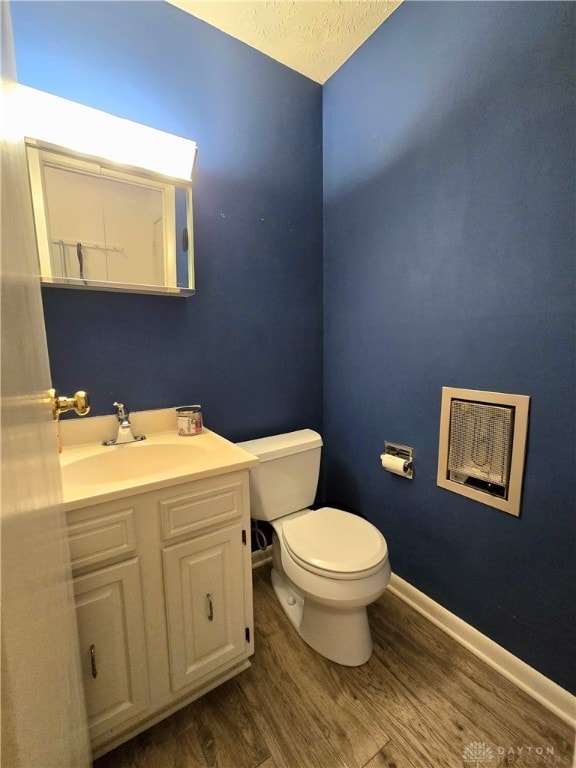 bathroom featuring toilet, vanity, a textured ceiling, and hardwood / wood-style flooring