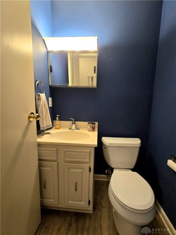 bathroom with toilet, vanity, and hardwood / wood-style flooring