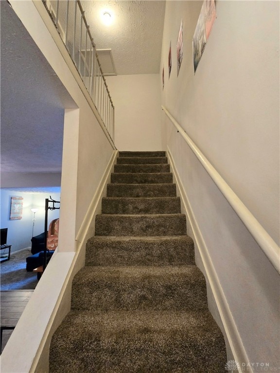 staircase with a textured ceiling