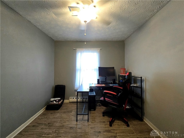 office area featuring wood-type flooring, a textured ceiling, ceiling fan, and a baseboard heating unit