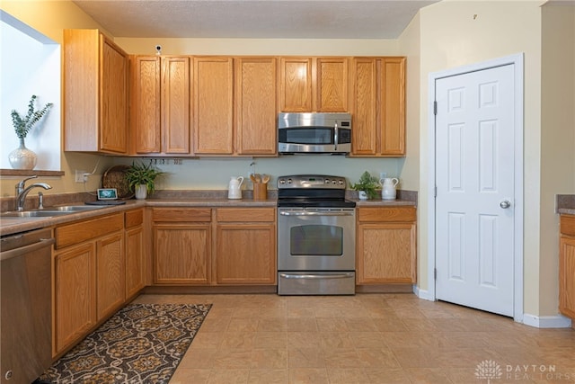 kitchen featuring sink, light tile patterned floors, and stainless steel appliances