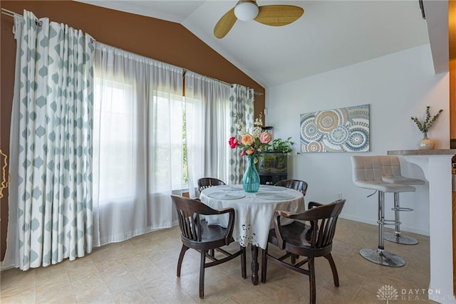 tiled dining area featuring ceiling fan and lofted ceiling