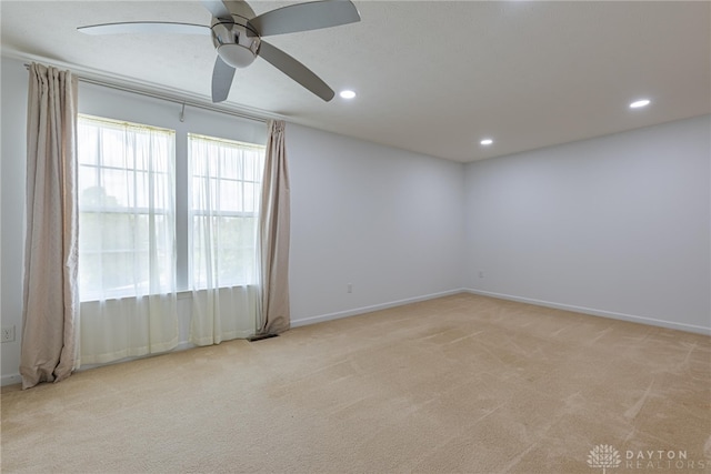 spare room with light colored carpet and ceiling fan