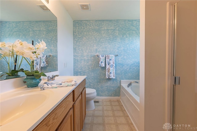 bathroom featuring tile patterned floors, a bath, toilet, and vanity