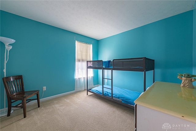 bedroom featuring light carpet and a textured ceiling