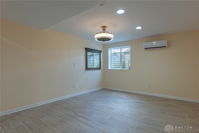 empty room with light wood-type flooring and a wall mounted AC