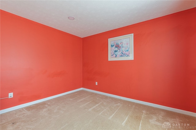 carpeted empty room featuring a textured ceiling