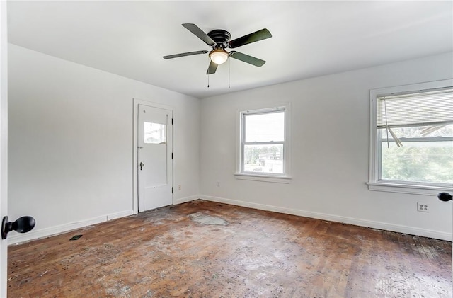 empty room featuring plenty of natural light, baseboards, and ceiling fan