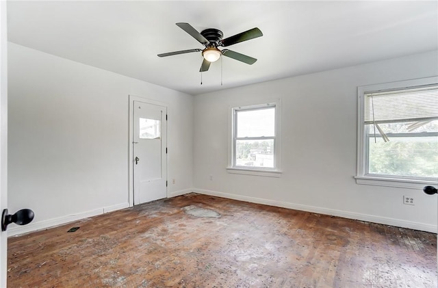spare room with baseboards, ceiling fan, and wood finished floors