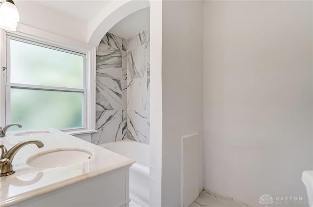 full bathroom with marble finish floor, bathtub / shower combination, double vanity, and a sink
