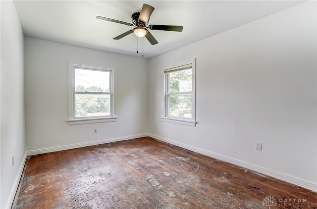 unfurnished room featuring a ceiling fan and baseboards