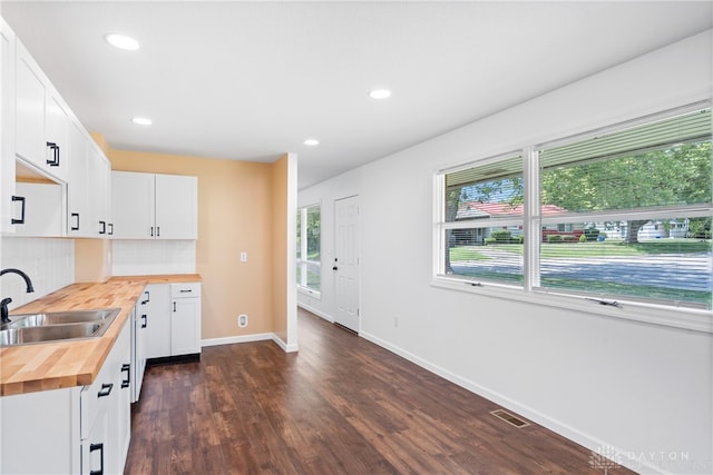 kitchen with plenty of natural light, sink, white cabinetry, and wood counters