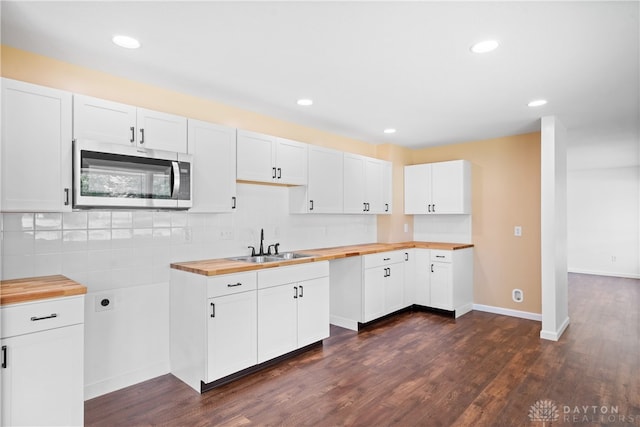 kitchen with white cabinetry, butcher block countertops, and dark hardwood / wood-style flooring