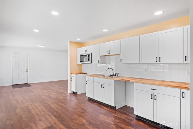 kitchen with dark hardwood / wood-style flooring, sink, white cabinets, and wood counters