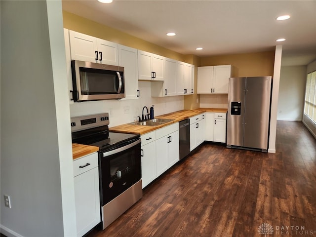 kitchen with white cabinets, wood counters, dark wood-type flooring, sink, and stainless steel appliances