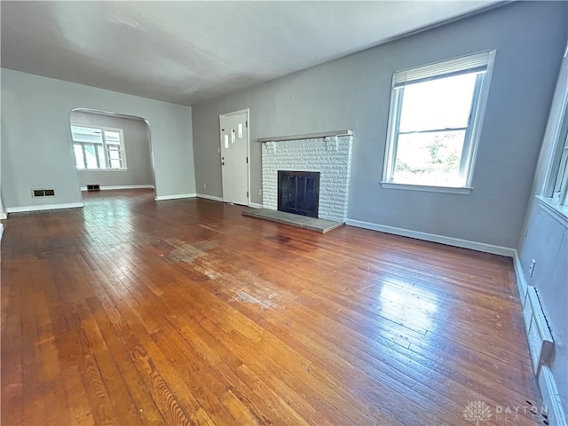 unfurnished living room featuring a fireplace and hardwood / wood-style flooring