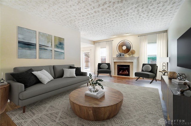 living room with a tile fireplace, wood-type flooring, and a textured ceiling