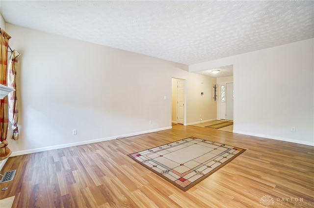 unfurnished room featuring hardwood / wood-style floors and a textured ceiling