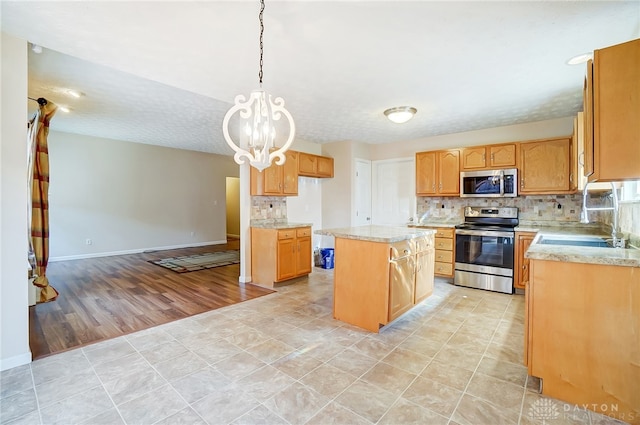 kitchen featuring stainless steel appliances, decorative light fixtures, light hardwood / wood-style flooring, a chandelier, and a center island