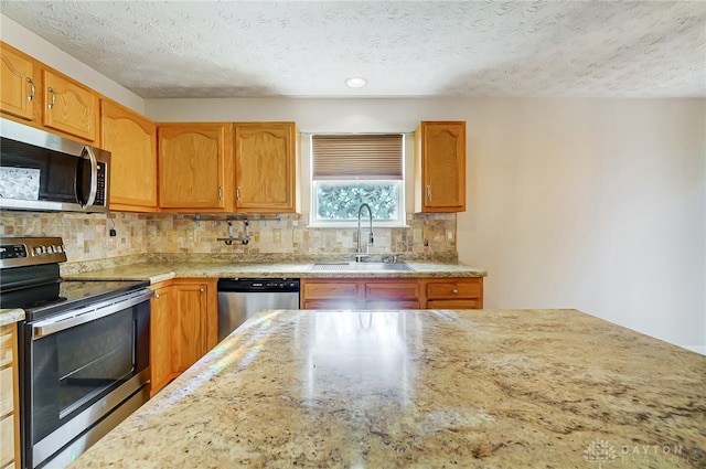 kitchen featuring a textured ceiling, backsplash, sink, and appliances with stainless steel finishes