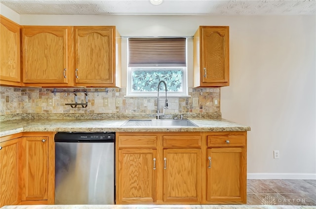 kitchen with stainless steel dishwasher, decorative backsplash, sink, and a textured ceiling