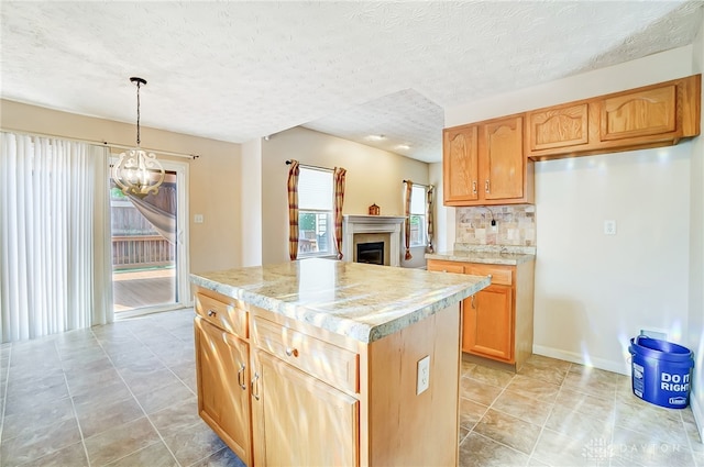 kitchen with a center island, an inviting chandelier, tasteful backsplash, a textured ceiling, and decorative light fixtures