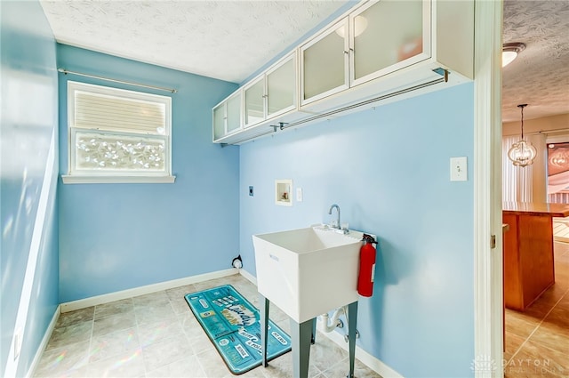 laundry room with cabinets, washer hookup, a textured ceiling, and electric dryer hookup