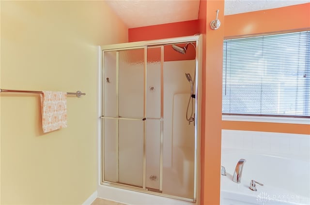 bathroom featuring a textured ceiling and a shower with shower door