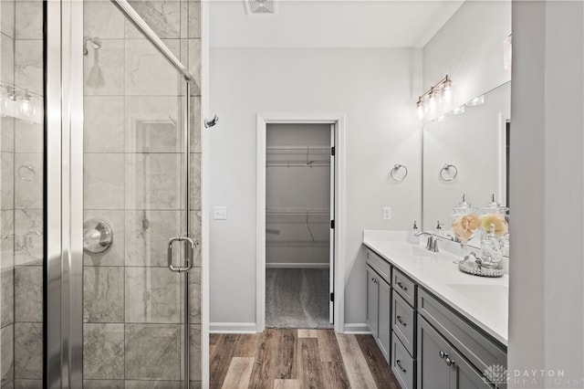 bathroom featuring walk in shower, vanity, and hardwood / wood-style floors