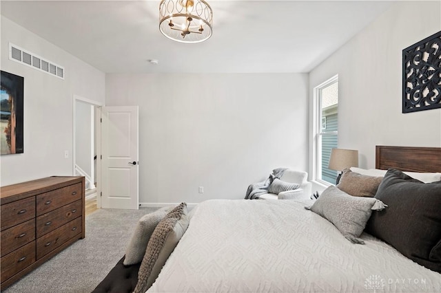 bedroom featuring an inviting chandelier and light carpet