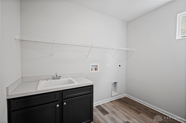 laundry area featuring light wood-type flooring, hookup for an electric dryer, cabinets, hookup for a washing machine, and sink