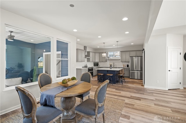 dining room with ceiling fan, light hardwood / wood-style flooring, and sink