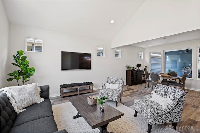 living room with light hardwood / wood-style flooring, high vaulted ceiling, and a healthy amount of sunlight