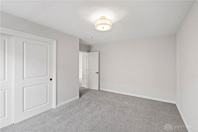 unfurnished bedroom featuring a closet and light colored carpet