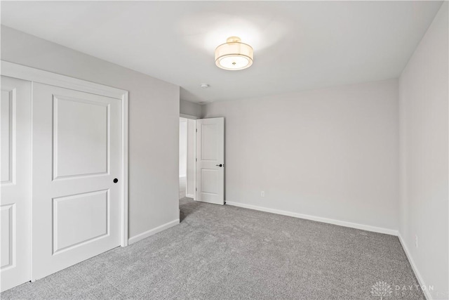 unfurnished bedroom featuring light colored carpet and a closet