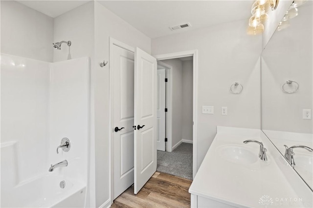 bathroom featuring hardwood / wood-style flooring, shower / washtub combination, and vanity