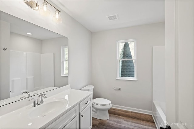 full bathroom with vanity, hardwood / wood-style flooring,  shower combination, and toilet