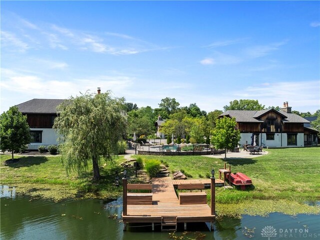 dock area featuring a water view and a lawn