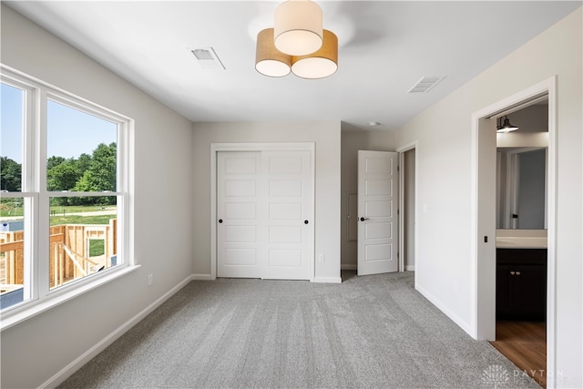 unfurnished bedroom featuring a closet and light colored carpet