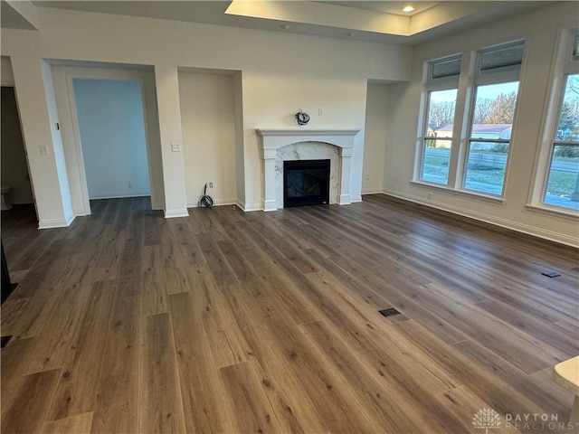 unfurnished living room with dark hardwood / wood-style floors and a premium fireplace