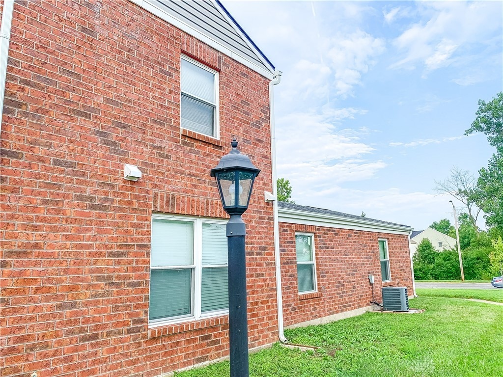 view of property exterior with a yard and central air condition unit