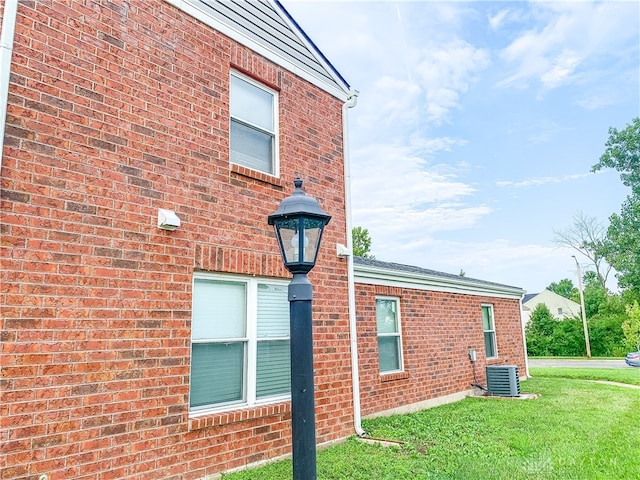 view of property exterior with a yard and central air condition unit