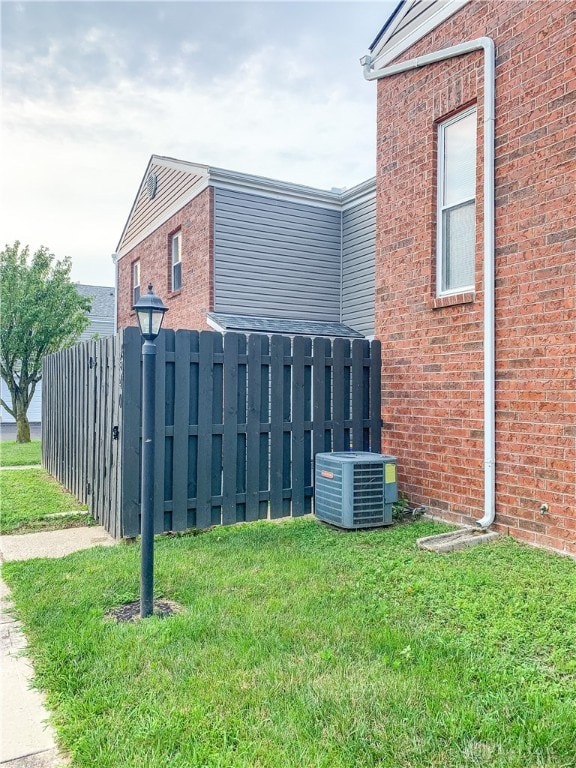 view of property exterior with cooling unit and a yard