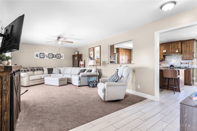 living room featuring ceiling fan and light hardwood / wood-style floors