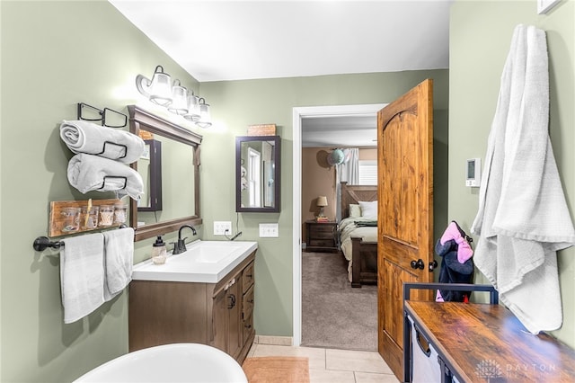 bathroom with vanity, a washtub, and tile patterned flooring