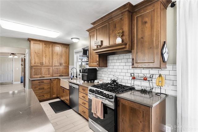 kitchen featuring appliances with stainless steel finishes, sink, light tile patterned floors, and decorative backsplash